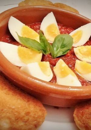 Una foto de Huevos duros  con sofrito de tomate y pan frito