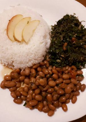 A picture of Rice served with beans and spinach.