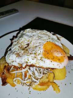Una foto de Patatas al ajo cabañil con gulas y huevo frito