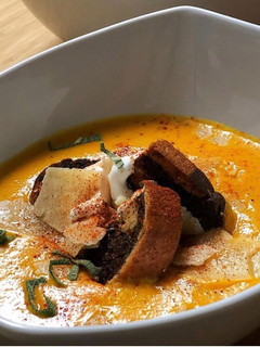 A picture of Roasted Sweet Potato & Carrot Soup with Marble Rye Croutons.