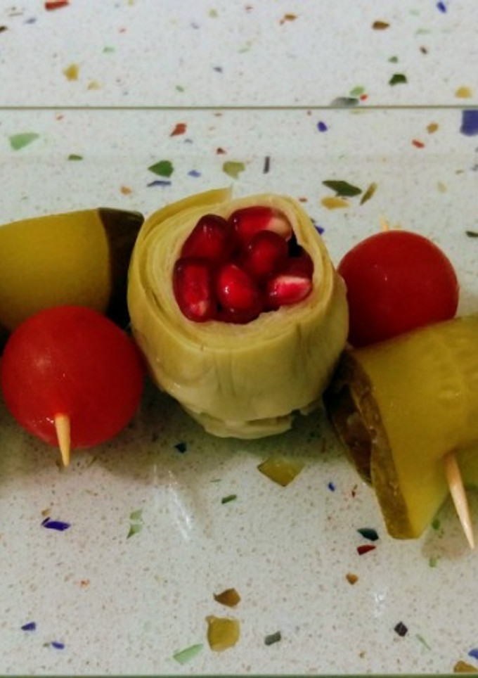 Una foto de Alcachofas con granada y pepinillos con cherrys