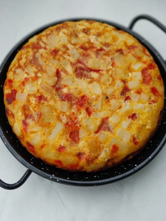 Una foto de Tortilla de patatas, pimiento rojo y ajo escalivado