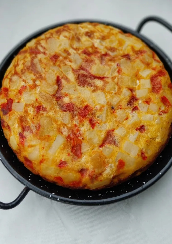 Una foto de Tortilla de patatas, pimiento rojo y ajo escalivado