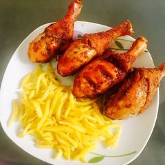 A picture of Peppered chicken drum sticks and chips.
