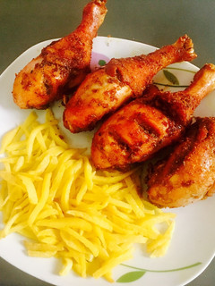 A picture of Peppered chicken drum sticks and chips.