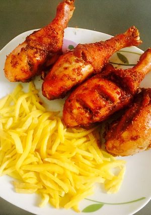 A picture of Peppered chicken drum sticks and chips.