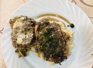 Una foto de Pechuga de Pollo rellena con champiñones al ajo y queso Crema, sobre cama de Puré de Papa