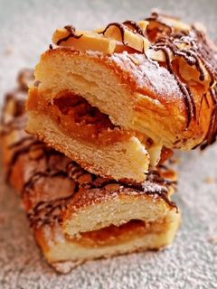 Una foto de Lazos de brioche hojaldrado relleno de turrón con chocolate