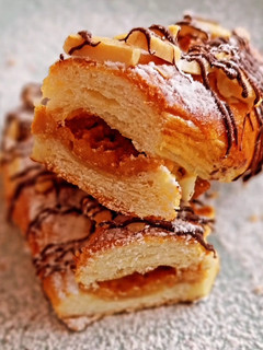 Una foto de Lazos de brioche hojaldrado relleno de turrón con chocolate