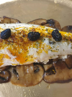 Una foto de Lubina asada sobre cama de setas de soja y pimentón🌶ajos negros