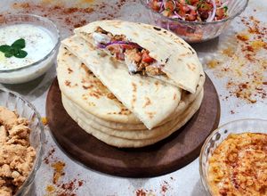 Una foto de 🥙Shawarma de pollo en pan pita 🥙 con vegetales y dos salsas 🥙