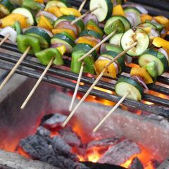 A picture of Grilled veggies and a 1/4 chicken.