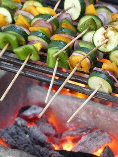 A picture of Grilled veggies and a 1/4 chicken.