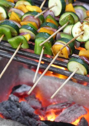 A picture of Grilled veggies and a 1/4 chicken.