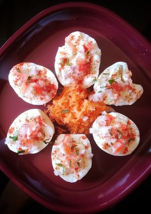 A picture of Boiled eggs with veggie toppings.