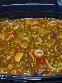 Una foto de Calamares en salsa de tomate y guisantes 😋