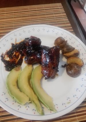 A picture of Pork Ribs with Homemade BBQ Sauce, Potatoes, and Avocado.