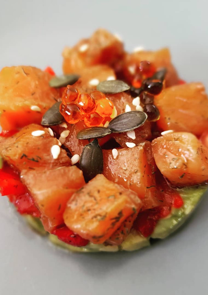 Una foto de Tartar de salmón marinado con aguacate y fresas