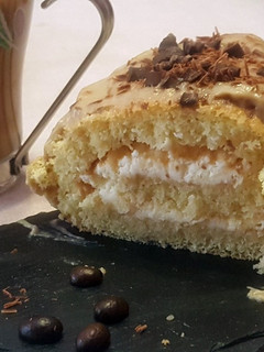 Una foto de Enrollado relleno de nata con cobertura de crema pastelera de café