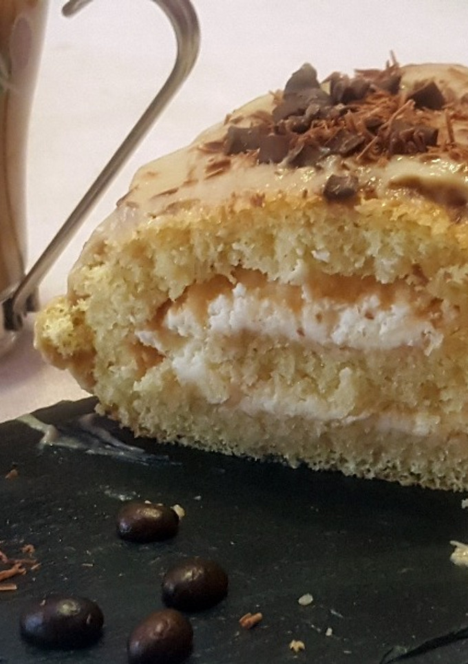 Una foto de Enrollado relleno de nata con cobertura de crema pastelera de café