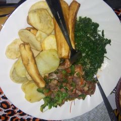 A picture of Deep fried potatoes and green bananas served with beef stew and spinach.