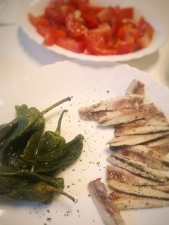 Una foto de Boquerones al horno con pimientos de Padrón