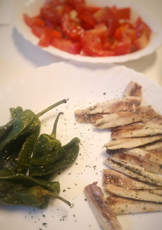 Una foto de Boquerones al horno con pimientos de Padrón