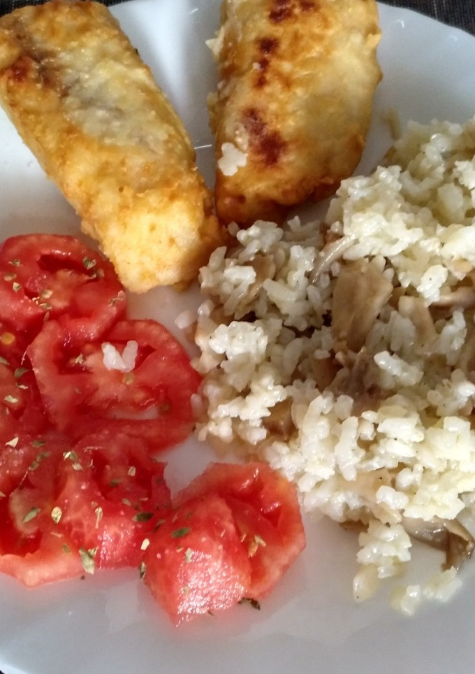 Una foto de Merluza frita con guarnición de arroz con setas y tomate