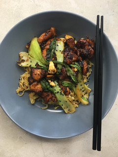 A picture of Cashew chicken with egg fried noodles.
