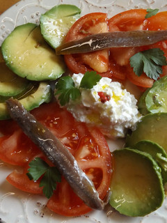 Una foto de Ensalada de aguacate y tomate con anchoas y queso granulado