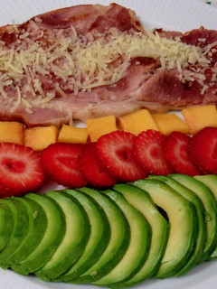 Una foto de Lacón ahumado asado con parmesano y ensalada de aguacate, papaya y fresas