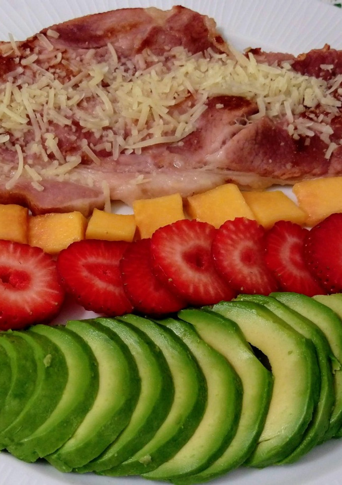Una foto de Lacón ahumado asado con parmesano y ensalada de aguacate, papaya y fresas