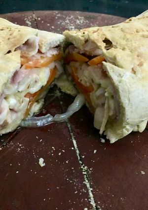 Una foto de Stromboli de jamón y tomate