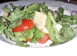 Una foto de Ensalada de rúcula, tomates cherry y parmesano