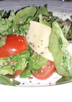 Una foto de Ensalada de rúcula, tomates cherry y parmesano