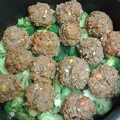 A picture of Kofta on a bed of broccoli.