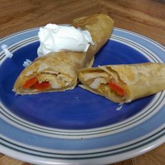 A picture of Seasoned Chicken & cheese wrap with bell peppers and sour cream..