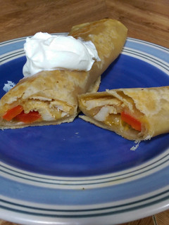 A picture of Seasoned Chicken & cheese wrap with bell peppers and sour cream..