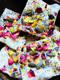 Una foto de Cuadrados de chocolate blanco con pétalos de rosa y cardamomo