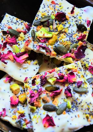 Una foto de Cuadrados de chocolate blanco con pétalos de rosa y cardamomo