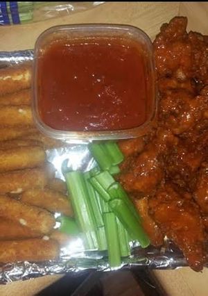 A picture of Gameday food homemade wings & mozzarella cheese sticks with marinara sauce.