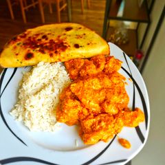 A picture of Chicken Tikka Masala with Naan bread.
