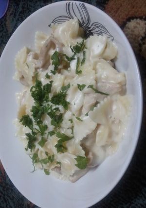A picture of pasta with white sauce and chicken.