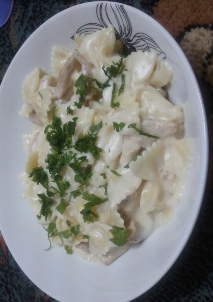 A picture of pasta with white sauce and chicken.