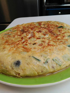 Una foto de Tortilla de patata, calabacín, setas y queso