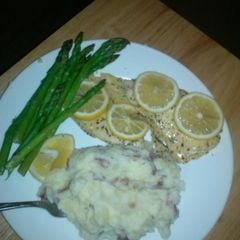A picture of Steamed tilipia with asparagus and lemon.