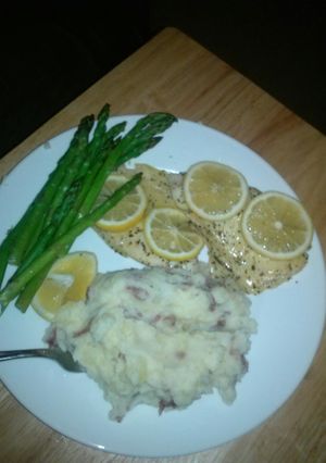 A picture of Steamed tilipia with asparagus and lemon.