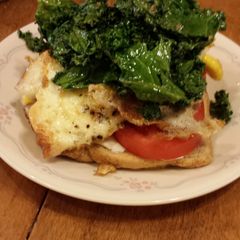 A picture of kale,tomato and cream cheese breakfast sandwich.