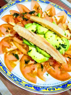 Una foto de Tomate aliñado con aguacate y ventresca de atún