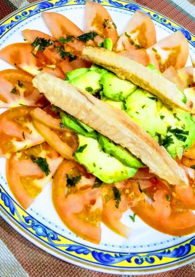 Una foto de Tomate aliñado con aguacate y ventresca de atún
